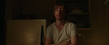 Movie still from “The Kitchen” (2019), directed by Andrea Berloff – A man sitting in front of a wall with his arms crossed; Close Up shot, Over the shoulder angle