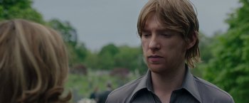 Movie still from “The Kitchen” (2019), directed by Andrea Berloff – A person wearing a gray shirt; Close Up shot, Over the shoulder angle