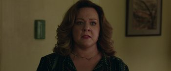 Movie still from “The Kitchen” (2019), directed by Andrea Berloff – An older woman with brown curly hair wearing a necklace; Close Up shot, Over the shoulder angle