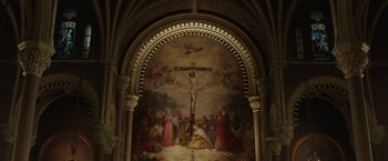 Movie still from “The Kitchen” (2019), directed by Andrea Berloff – A painting of a crucifixion scene in a church; Extreme Wide shot, High angle
