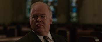 Movie still from “The Kitchen” (2019), directed by Andrea Berloff – An older man wearing a suit and tie; Close Up shot, Over the shoulder angle