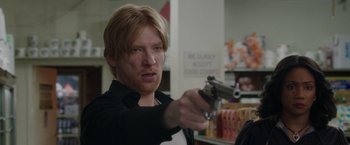 Movie still from “The Kitchen” (2019), directed by Andrea Berloff – A man holding a gun pointed at the camera; Close Up shot, Over the shoulder angle