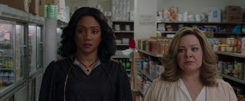 Movie still from “The Kitchen” (2019), directed by Andrea Berloff – Two women standing in a store looking at each other; Close Up shot, Over the shoulder angle