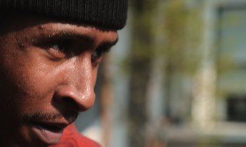 A man's face with sweat coming off of his face