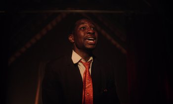 A man wearing a suit and tie with his mouth wide open