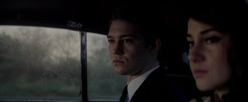 Movie still from “The Last Letter from Your Lover” (2021), directed by Augustine Frizzell – A man in a suit and tie in front of a window; Close Up shot, Low angle