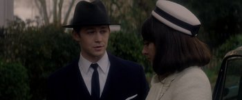 Movie still from “The Last Letter from Your Lover” (2021), directed by Augustine Frizzell – A man and a woman wearing suits and hats; Close Up shot, Over the shoulder angle