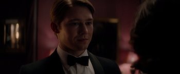 Movie still from “The Last Letter from Your Lover” (2021), directed by Augustine Frizzell – A person wearing a suit and a bow tie; Close Up shot, Over the shoulder angle