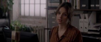 Movie still from “The Last Letter from Your Lover” (2021), directed by Augustine Frizzell – A woman in a brown polka dot shirt looking at the camera; Close Up shot, Over the shoulder angle