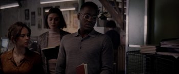 Movie still from “The Last Letter from Your Lover” (2021), directed by Augustine Frizzell – A man with glasses holding a book in his hands; Medium shot, Over the shoulder angle