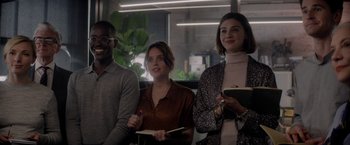 Movie still from “The Last Letter from Your Lover” (2021), directed by Augustine Frizzell – A group of people sitting next to each other in a room; Medium shot, Over the shoulder angle