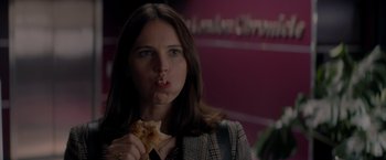 Movie still from “The Last Letter from Your Lover” (2021), directed by Augustine Frizzell – A woman is holding a piece of pizza in her hand; Close Up shot, Over the shoulder angle