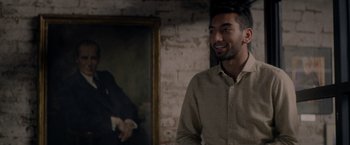 Movie still from “The Last Letter from Your Lover” (2021), directed by Augustine Frizzell – A man standing in front of a painting; Medium shot, Over the shoulder angle
