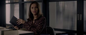 Movie still from “The Last Letter from Your Lover” (2021), directed by Augustine Frizzell – A woman sitting at a table in a room; Close Up shot, Over the shoulder angle