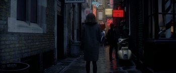 Movie still from “The Last Letter from Your Lover” (2021), directed by Augustine Frizzell – A woman is walking down the street at night; Wide shot, Over the shoulder angle