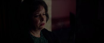 Movie still from “The Last Letter from Your Lover” (2021), directed by Augustine Frizzell – An older woman looking sad while sitting in a chair; Close Up shot, Over the shoulder angle