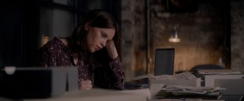 Movie still from “The Last Letter from Your Lover” (2021), directed by Augustine Frizzell – A woman sitting in front of a laptop computer; Medium shot, High angle