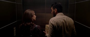 Movie still from “The Last Letter from Your Lover” (2021), directed by Augustine Frizzell – A man and a woman are standing in an elevator; Medium shot, Over the shoulder angle