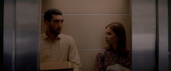 Movie still from “The Last Letter from Your Lover” (2021), directed by Augustine Frizzell – A man and a woman sitting next to each other; Medium shot, Over the shoulder angle