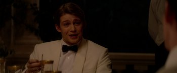 Movie still from “The Last Letter from Your Lover” (2021), directed by Augustine Frizzell – A man in a white suit and a black bow tie; Close Up shot, Over the shoulder angle