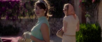 Movie still from “The Last Letter from Your Lover” (2021), directed by Augustine Frizzell – A woman in a green dress and a woman in a blue dress; Medium shot, Over the shoulder angle