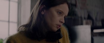 Movie still from “The Last Letter from Your Lover” (2021), directed by Augustine Frizzell – A young woman is holding a phone up to her ear; Close Up shot, High angle