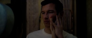 Movie still from “The Last Letter from Your Lover” (2021), directed by Augustine Frizzell – A man holding a cell phone up to his ear; Close Up shot, Low angle