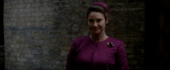 Movie still from “The Last Letter from Your Lover” (2021), directed by Augustine Frizzell – A woman wearing a purple dress and a purple hat; Close Up shot, Over the shoulder angle