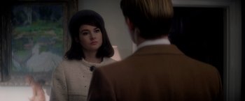 Movie still from “The Last Letter from Your Lover” (2021), directed by Augustine Frizzell – A woman looking in the mirror while wearing a hat; Close Up shot, Over the shoulder angle