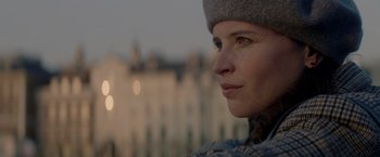Movie still from “The Last Letter from Your Lover” (2021), directed by Augustine Frizzell – A person wearing a hat looking to the side; Close Up shot, Low angle