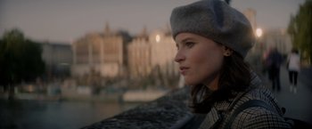 Movie still from “The Last Letter from Your Lover” (2021), directed by Augustine Frizzell – A woman wearing a hat looking out over the water; Close Up shot, Low angle