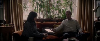 Movie still from “The Last Letter from Your Lover” (2021), directed by Augustine Frizzell – A man and a woman sitting in a living room; Medium shot, Over the shoulder angle