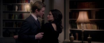 Movie still from “The Last Letter from Your Lover” (2021), directed by Augustine Frizzell – A man and a woman standing next to each other in a room; Medium shot, Over the shoulder angle