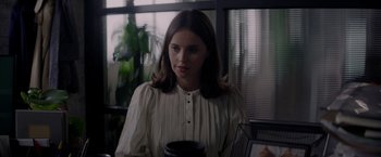 Movie still from “The Last Letter from Your Lover” (2021), directed by Augustine Frizzell – A woman in a white shirt is holding a coffee mug; Medium shot, Over the shoulder angle