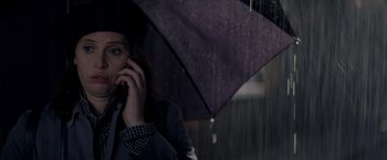 Movie still from “The Last Letter from Your Lover” (2021), directed by Augustine Frizzell – A woman holding an umbrella while talking on the phone; Close Up shot, Low angle