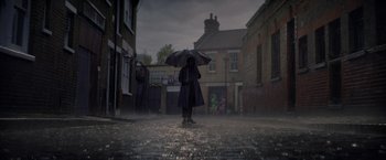 Movie still from “The Last Letter from Your Lover” (2021), directed by Augustine Frizzell – A person holding an umbrella in the middle of a street; Extreme Wide shot, Low angle