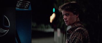 Movie still from “The Last Starfighter” (1984), directed by Nick Castle – A young man standing on the side of the street; Close Up shot, Low angle