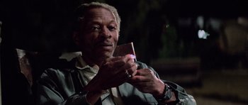 Movie still from “The Last Starfighter” (1984), directed by Nick Castle – An older man looking at his cell phone; Close Up shot, Low angle