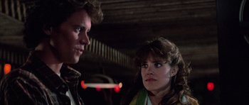 Movie still from “The Last Starfighter” (1984), directed by Nick Castle – A man and a woman standing next to each other; Close Up shot, Over the shoulder angle