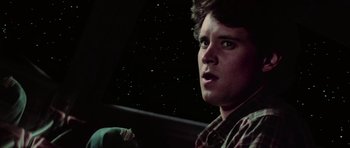 Movie still from “The Last Starfighter” (1984), directed by Nick Castle – A man in a plaid shirt is sitting in a car; Close Up shot, Low angle