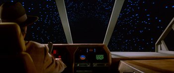 Movie still from “The Last Starfighter” (1984), directed by Nick Castle – A view from inside an airplane looking out the window at the stars; Medium shot, Low angle