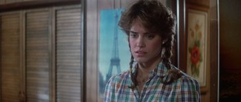 Movie still from “The Last Starfighter” (1984), directed by Nick Castle – A woman with braids and a plaid shirt in front of the eiffel tower; Close Up shot, Over the shoulder angle