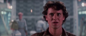 Movie still from “The Last Starfighter” (1984), directed by Nick Castle – A young man with curly brown hair stares into the camera; Close Up shot, Low angle