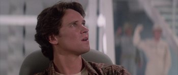 Movie still from “The Last Starfighter” (1984), directed by Nick Castle – A man sitting in a chair looking up at the sky; Close Up shot, Low angle