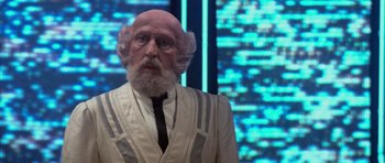 Movie still from “The Last Starfighter” (1984), directed by Nick Castle – An old man with a bald head wearing a suit and tie; Close Up shot, Low angle