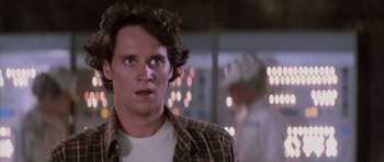 Movie still from “The Last Starfighter” (1984), directed by Nick Castle – A man with a beard is looking at the camera; Close Up shot, Over the shoulder angle