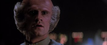 Movie still from “The Last Starfighter” (1984), directed by Nick Castle – A man with a bald head and white hair looking at the camera; Close Up shot, Low angle
