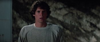 Movie still from “The Last Starfighter” (1984), directed by Nick Castle – A young man in a gray shirt is looking to his left; Close Up shot, Over the shoulder angle