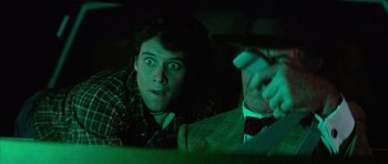 Movie still from “The Last Starfighter” (1984), directed by Nick Castle – A young man and an older man in a dark room; Close Up shot, Over the shoulder angle