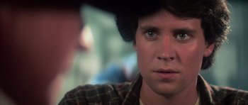 Movie still from “The Last Starfighter” (1984), directed by Nick Castle – A man's face in a plaid shirt; Close Up shot, Over the shoulder angle